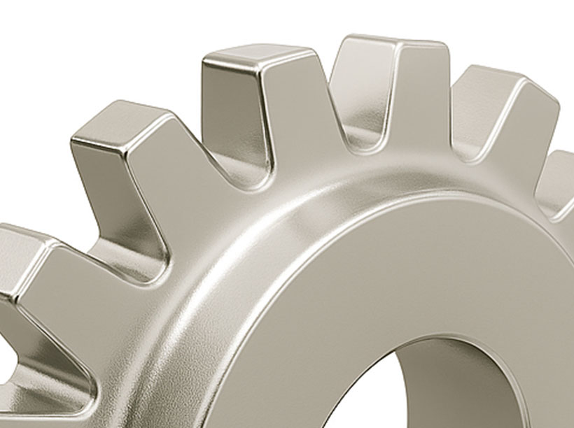 Close-up of a metallic gear with evenly spaced teeth, showing part of its circular shape against a plain white background.